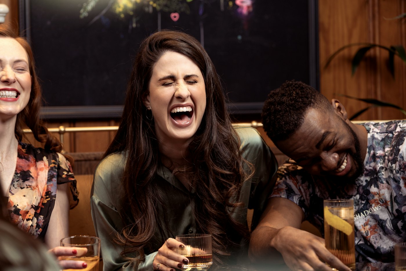 Friends sharing drinks and laughing around a café table